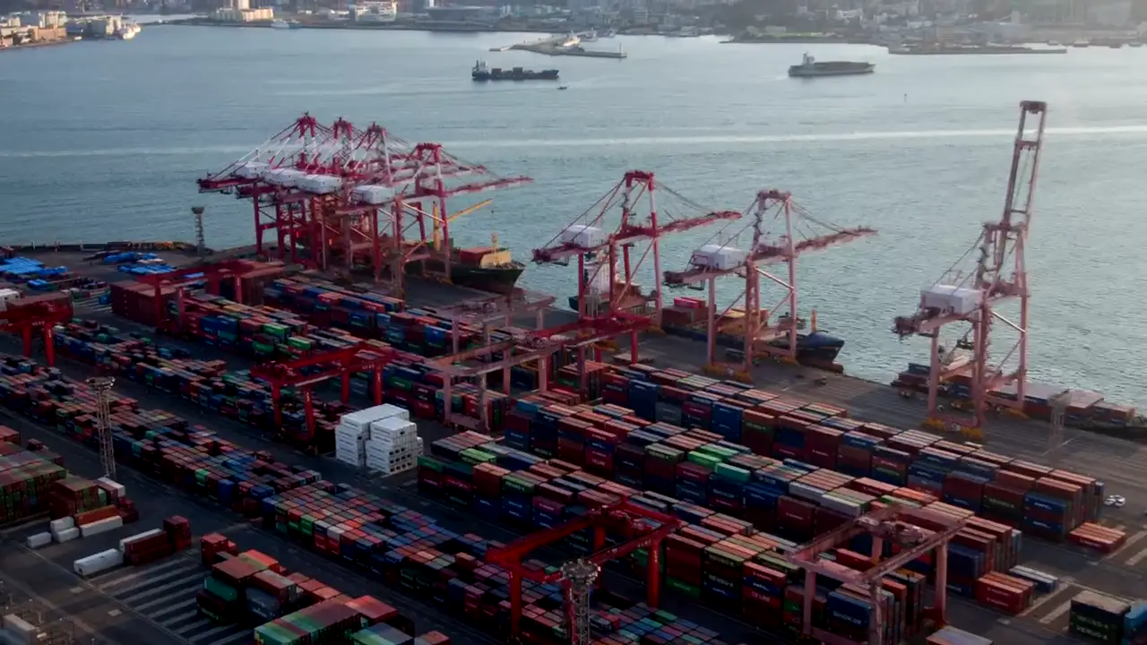 Vista aerea di un terminal container con gru rosse, luce dorata
