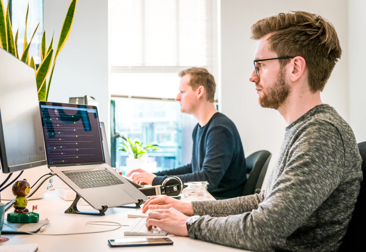 Dwóch programistów przy laptopach w software housie