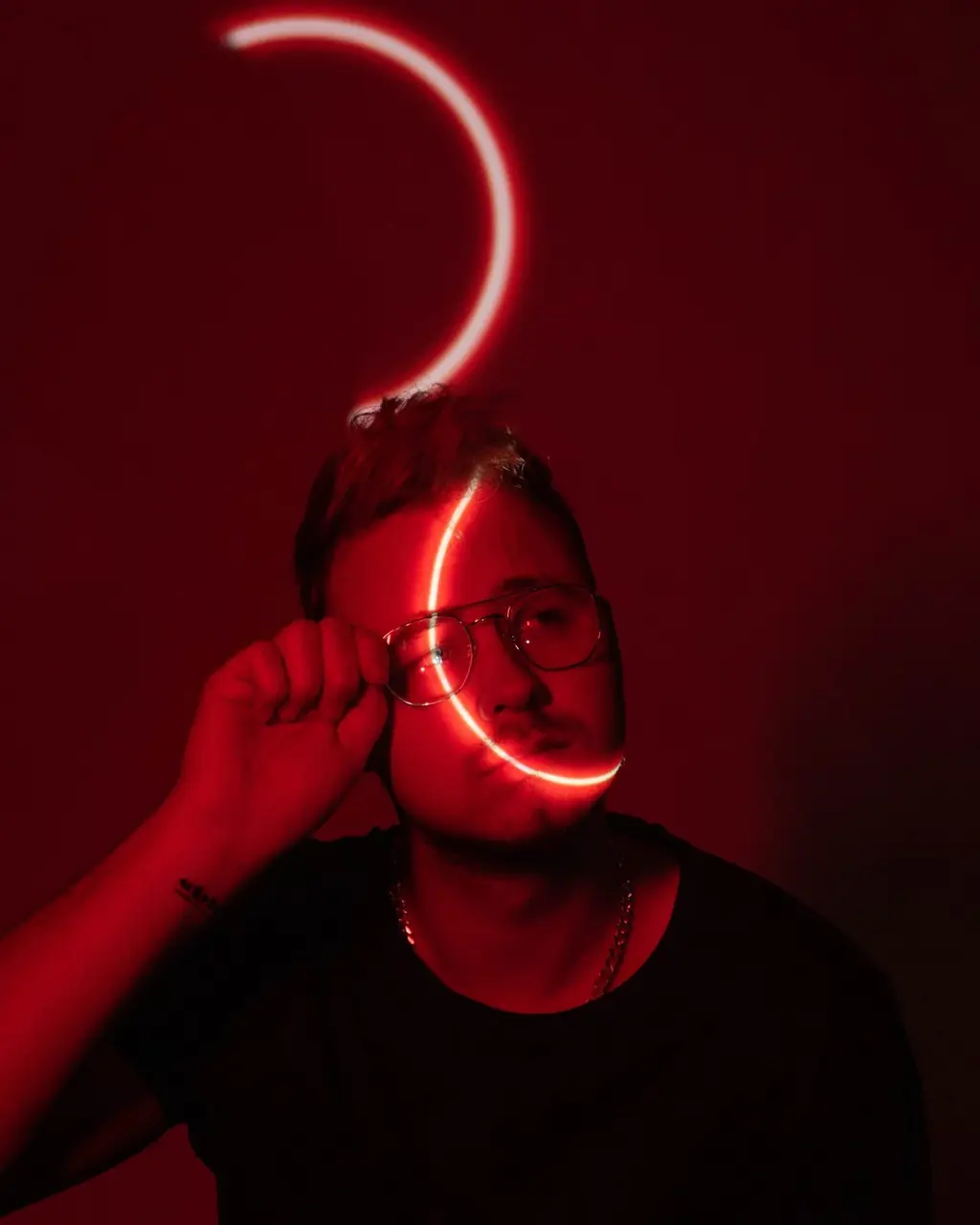 Portret w czerwonym świetle z neonowym łukiem nad głową